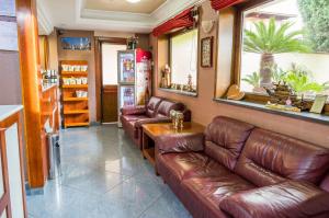 a living room with leather couches and a refrigerator at cupido park in Licola