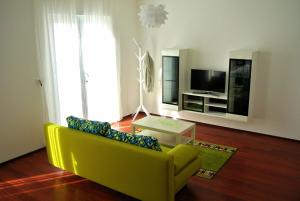 een woonkamer met een gele bank en een tv bij 55 & 54 Stairs Apartments in Dubrovnik