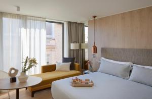 a hotel room with a bed and a couch at ME Barcelona in Barcelona