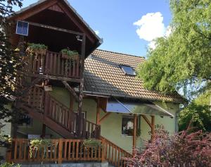 ein Haus mit einer Veranda und einem Balkon in der Unterkunft Zöld Vendégház in Csernely
