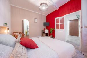 1 dormitorio con cama blanca y pared roja en **APPARTEMENT PROCHE GARE ET MARCHE DE TOULON**, en Toulon