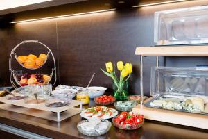 格拉茨威尔格施罗森餐厅酒店的厨房配有带一些食物和鲜花的柜台