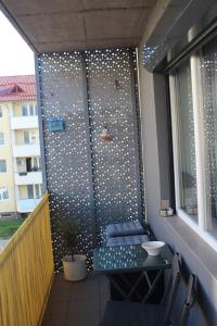 a privacy screen on a balcony with a table and chairs at Stefanos Apartament in Baia Mare