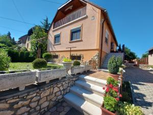 a house with stairs and flowers in front of it at Fenyves Vendèghàz in Tapolca