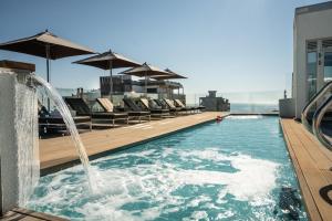 a swimming pool with a fountain on top of a building at Bellini Relais in Lignano Sabbiadoro