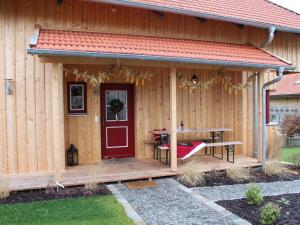 a wooden cabin with a red door and a picnic table at Ferienhaus Wankner in Tittmoning