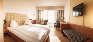 una camera d'albergo con letto e TV di Vulkanlandhotel Legenstein a Bad Gleichenberg