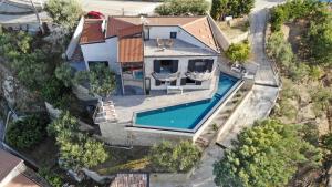 een uitzicht op een huis met een zwembad bij VILLA LA VISTA 6&2, Emma Villas in Capo dʼOrlando