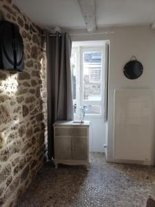 Cette chambre dispose d'une fenêtre et d'une table avec une lampe. dans l'établissement maison de pécheur typique presqu’île Saint Jacut Sur Mer, à Saint-Jacut-de-la-Mer