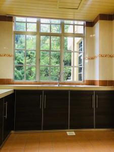a kitchen with a sink and a large window at BRINCHANG CENTRE 3 ROOMS APARTMENT in Cameron Highlands