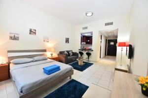 a bedroom with a bed and a living room at Budget-Friendly Studio Near Metro - Spacious & Calm - VRN in Dubai