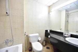 a bathroom with a toilet and a sink and a mirror at Budget-Friendly Studio Near Metro - Spacious & Calm - VRN in Dubai