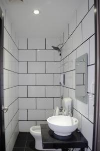 a white bathroom with a sink and a toilet at M Season Boutique Hotel Sdn Bhd in Sungai Petani