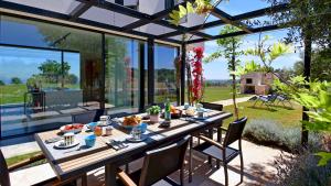 een tafel met eten erop in een glazen huis bij VILLA SPECCHIO DI MARE 8, Emma Villas in Polignano a Mare