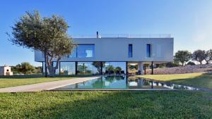 een huis met een zwembad ervoor bij VILLA SPECCHIO DI MARE 8, Emma Villas in Polignano a Mare
