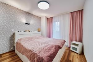 Un dormitorio con una cama grande y una ventana en LAGUNA Apartament Polanica Residence 48, en Polanica-Zdrój