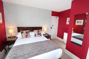 a red bedroom with a bed and two lamps at Fern Howe Guest House in Keswick