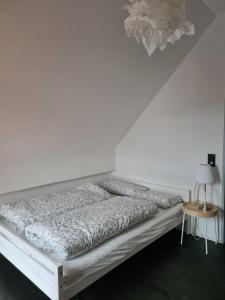 a bed in a room with a white wall at Maisonette-Wohnung mit Balkon in Radolfzell am Bodensee