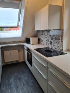 a kitchen with white cabinets and a window at Maisonette-Wohnung mit Balkon in Radolfzell am Bodensee
