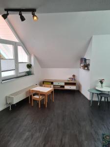 an attic room with a table and a desk and a window at Maisonette-Wohnung mit Balkon in Radolfzell am Bodensee