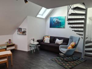 a living room with a couch and a spiral staircase at Maisonette-Wohnung mit Balkon in Radolfzell am Bodensee