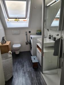 a bathroom with a toilet and a sink and a window at Maisonette-Wohnung mit Balkon in Radolfzell am Bodensee