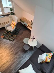 a living room with a couch and a chair at Maisonette-Wohnung mit Balkon in Radolfzell am Bodensee