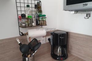 encimera de cocina con cafetera y utensilios en SV 8 -Les Ecureuils bel appartement dans une résidence calme et sécurisée, en Saint-Valery-sur-Somme