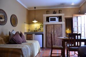 a bedroom with a bed and a table and a microwave at Gecko Cottage Guesthouse in Prieska