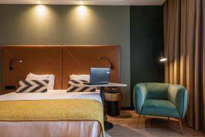 una habitación de hotel con una cama y un ordenador portátil en una mesa en Shanghai Hotel Holland, en Delft
