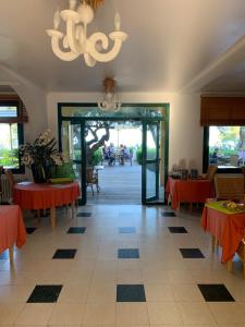 a dining room with red tables and a chandelier at Hotel Thalassa in Cargèse