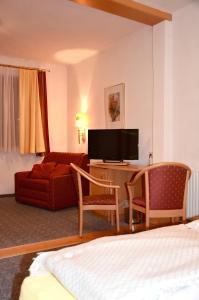 a hotel room with a bed and a desk with a television at Sport Aktiv Pension Spanner - Tauplitz in Bad Mitterndorf