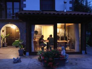 zwei Personen sitzen nachts an einem Tisch auf einer Terrasse in der Unterkunft Baiolei in Azpeitia