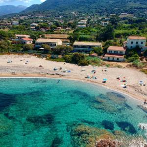 an aerial view of a beach with people in the water at Hotel Thalassa in Cargèse