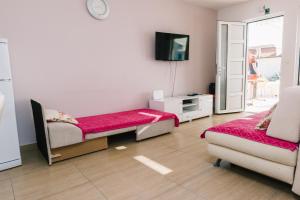 Televízia a/alebo spoločenská miestnosť v ubytovaní Apartmani Mila Brela