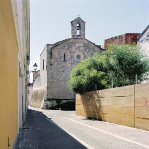 奧里斯塔諾的住宿－Monastero Santa Chiara Guest House，一条小巷,有一座古老的建筑,有钟楼