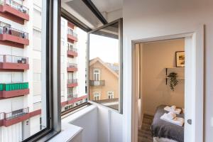 Una habitación con una ventana y vista a un edificio. en Seaside 1BR Flat w/ AC in Matosinhos by LovelyStay, en Matosinhos