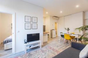 Una sala de estar con televisión y un comedor. en Seaside 1BR Flat w/ AC in Matosinhos by LovelyStay, en Matosinhos