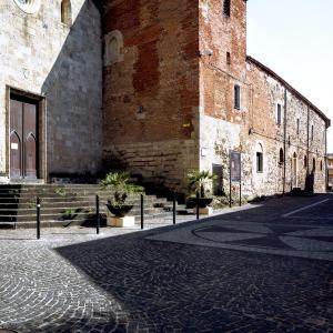 un gran edificio de ladrillo con una calle delante en Monastero Santa Chiara Guest House, en Oristano