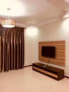 a living room with a flat screen tv on a wall at BRINCHANG CENTRE 3 ROOMS APARTMENT in Cameron Highlands