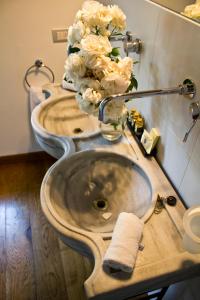 - deux lavabos dans une salle de bains avec des fleurs sur le comptoir dans l'établissement Tenuta San Pietro Luxury Hotel, à Lucques