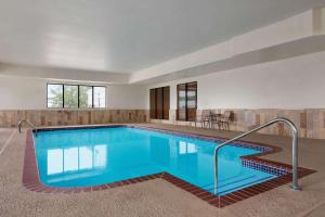 a swimming pool with blue water in a building at Wingate by Wyndham Bentonville in Bentonville