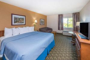a hotel room with a bed and a television at Days Inn by Wyndham Kirksville in Kirksville