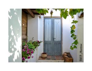 a door in the side of a house with flowers at B&B Martina in San Vito