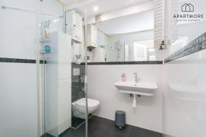 a white bathroom with a toilet and a sink at Old Town by Apartmore in Gdańsk +26 photos