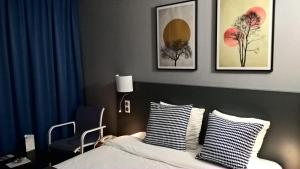 1 dormitorio con 1 cama y algunas fotos en la pared en Hotel Tambourin en Vitry-le-François