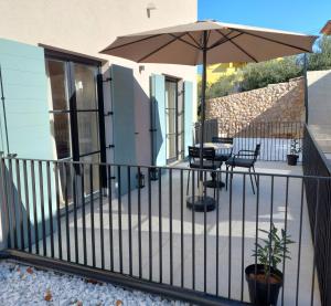 a balcony with a table and an umbrella at DESIGN hotel VERBENICUM in Vrbnik
