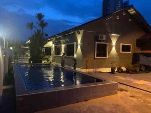 a house with a swimming pool in front of a house at MELAKA BEACH VILLA ( B TYPE ) in Malacca