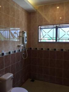 a bathroom with a shower and a toilet and a window at MELAKA BEACH VILLA ( B TYPE ) in Melaka
