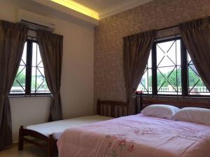 a bedroom with two beds and two windows at MELAKA BEACH VILLA ( B TYPE ) in Melaka